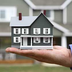 hand holding a miniature house